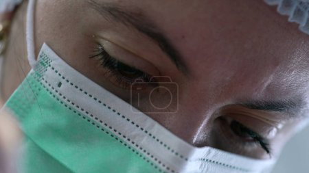 Photo for Detail of Female Surgeon Engaged in Clinical Surgery, close-up face, Focused Female Doctor Performing Surgical Procedure - Royalty Free Image