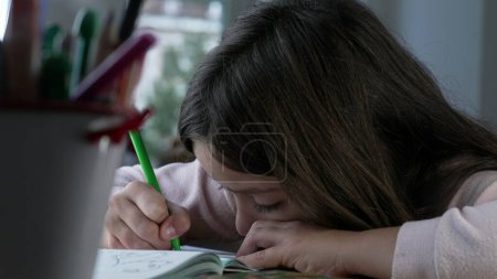 Foto de Dibujo artístico de niña en papel con pluma para colorear verde, niño concentrado enfocado dedicado al juego creativo - Imagen libre de derechos