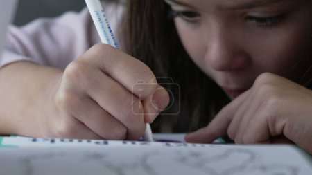 Gros plan sur les mains de l'enfant mettant le capuchon du stylo - la petite fille termine la session de coloration