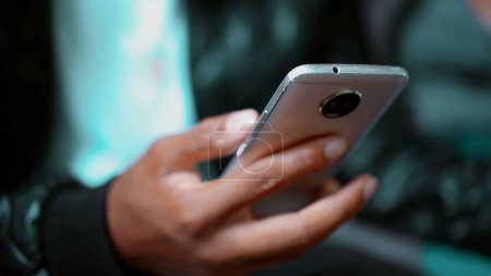 Photo for Close-up of person holding cellphone device consuming social media online. Back of smartphone - Royalty Free Image