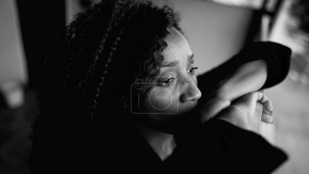 Photo for Contemplative South American Latina in 50s, Deep Rumination on Balcony in Monochrome, middle-aged female person struggling with depression gazing at distance from residence - Royalty Free Image