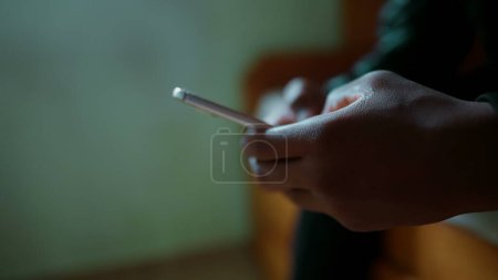 Photo for Close-up hand typing on cellphone device. One young black man's hands holding phone engaged in modern communication - Royalty Free Image