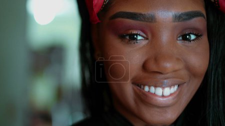 Photo for One joyful black latina adult girl in 20s smiling at camera. Portrait of South American young woman of African descent with wide grin, looking directly at camera - Royalty Free Image