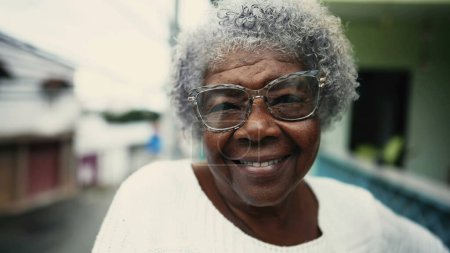 Téléchargez les photos : Portrait of Joyful 80s African Descent Senior Woman with Gray Hair on Balcony, gros plan de personnes âgées sud-américaines âgées cheveux gris personne âgée avec un sourire amical - en image libre de droit