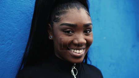 Téléchargez les photos : Urban Portrait of Smiling Young Black Woman, Latina sud-américaine dans un cadre urbain, plan rapproché dynamique de la personne dans les années 20 - en image libre de droit