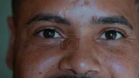Photo for South American young black man smiling at camera, macro close-up eyes of 20s person of diverse ethnicity - Royalty Free Image