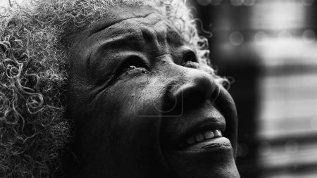 Photo for Macro Close-Up of Wrinkled Mature Black Woman with Gray Hair GAZES upwards feeling the presence of a higher power in black and white, monochromatic - Royalty Free Image