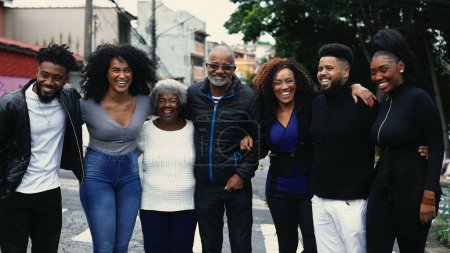 Photo for Group of Joyful Brazilian people smiling and laughing together standing in city street posing for camera. United Family of African descent embrace - Royalty Free Image