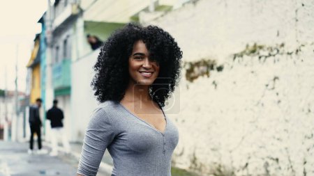 Femme d'ascendance africaine confiante marchant dans la ville urbaine d'Amérique du Sud, une femme noire aux cheveux bouclés fuyant la joie et l'autonomisation