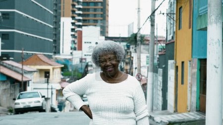 Photo for Portrait of a South American older lady standing in urban city street. African American 80s woman posing for camera outside - Royalty Free Image