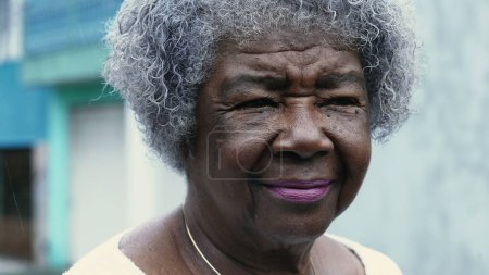 Téléchargez les photos : Une chère dame noire avec le visage ridé et les cheveux gris. Portrait d'une vieille afro-américaine dans les années 80 montrant la sagesse et la vieillesse avec un regard réfléchi - en image libre de droit