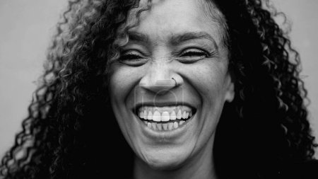 Foto de Cara monocromática de cerca de una alegre mujer de los años 40 de Sudamérica sonriendo y riendo. Una feliz dama afrodescendiente de mediana edad en blanco y negro - Imagen libre de derechos