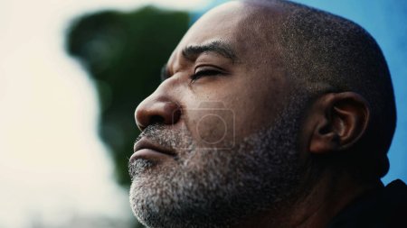 Foto de Un pensativo meditativo hombre hispano negro de mediana edad cerrando los ojos en contemplación. Primer plano de una persona sudamericana de los años 50 en pensamiento profundo y atención plena - Imagen libre de derechos