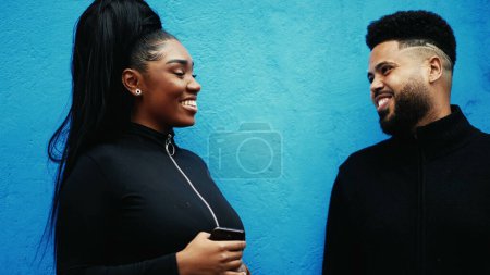 Photo for Happy South American Brazilian people laughing and smiling together standing in urban wall in city sidewalk. Male and female friends interaction - Royalty Free Image