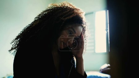 Téléchargez les photos : Une femme noire d'âge moyen préoccupée ressent anxiété et inquiétude par la contemplation au chevet du patient. Pensée années 50 personne dans le désespoir calme à l'intérieur - en image libre de droit