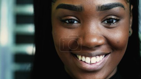 Téléchargez les photos : Une jeune adolescente noire heureuse souriant à la caméra en détail macro gros plan, regardant directement la caméra. Jeune femme sud-américaine d'origine africaine - en image libre de droit
