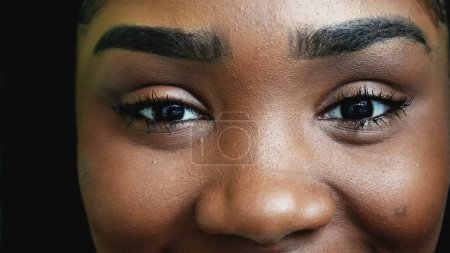 Foto de Una joven negra cerrando los ojos en meditación, una chica adulta afroamericana practicando mindfulness, abre los ojos al cielo en macro detalle de primer plano sonriendo - Imagen libre de derechos