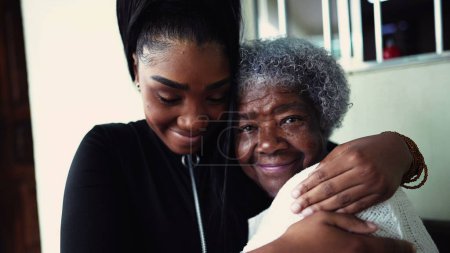 Téléchargez les photos : Petite-fille afro-américaine embrassant une grand-mère âgée des années 80 montrant un soutien et une aide pour un membre de la famille intergénérationnelle. Unité familiale et amour pendant la vieillesse - en image libre de droit