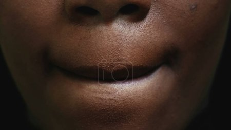Téléchargez les photos : Macro détail gros plan de la bouche d'une fille noire lécher les lèvres avec la langue - en image libre de droit