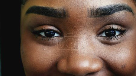 Foto de Una joven latina negra feliz con mirada intensa sonriendo a la cámara, Macro Close-Up Eyes of teen woman - Imagen libre de derechos