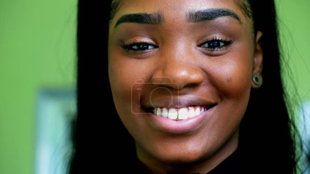 Foto de Una joven joven y feliz adolescente negro sonriendo a la cámara en detalle macro primer plano, mirando directamente a la cámara. Mujer joven Sudamericana de ascendencia africana - Imagen libre de derechos