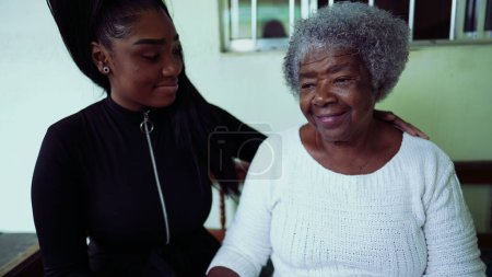 Generationenübergreifendes Familienerlebnis - Teenage Enkelin kümmert sich um betagte 80er-Jahre-Großmutter in authentischer Manier von Liebe und Zuneigung mit Arm um Schulter und angewinkelten Stirnen