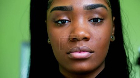 Foto de Una joven adolescente latina negra mirando fijamente a la cámara con expresión solemne, rasgos faciales cercanos de una persona de 20 años de ascendencia africana - Imagen libre de derechos