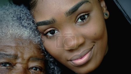 Foto de Retrato de la joven nieta junto a la arrugada abuela, dos generaciones en primer plano de contraste facial. Latinoamericanos sudamericanos de ascendencia africana - Imagen libre de derechos