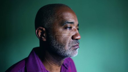 Photo for One pensive senior black man regretting past decision grimacing during challenging times standing indoors in isolation gazing at window, profile close-up face - Royalty Free Image