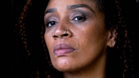 Eine ernstzunehmende schwarze Frau mittleren Alters, die mit starkem Blick in die Kamera blickt, verärgert über den urteilenden Gesichtsausdruck einer afroamerikanischen 50er-Jahre-Dame