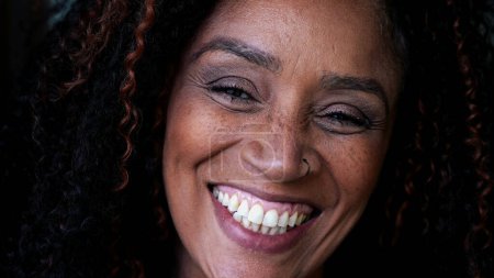 Téléchargez les photos : Une heureuse femme noire d'âge moyen en gros plan souriant à la caméra. Femme sud-américaine d'ascendance africaine - en image libre de droit