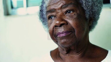 Foto de Una anciana negra pensativa con canas y arrugas. Cara de retrato afroamericana de los años 80 de cerca con expresión reflexiva escuchando e interactuando en la conversación - Imagen libre de derechos