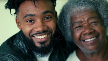 Photo for Happy Contrast in Ages - Portrait of Elderly Grandmother in 80s next to her adult 20s son close-up faces smiling at camera - Royalty Free Image