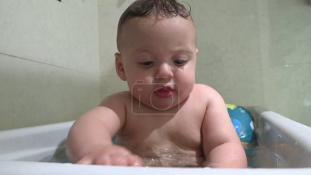 Photo for Baby bathing inside bathtub playing with water - Royalty Free Image