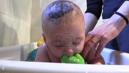 Photo for Bathing cute baby infant inside bathtub - Royalty Free Image