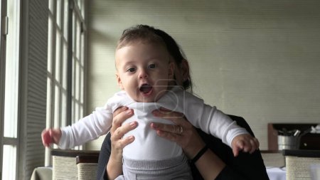 Téléchargez les photos : Mère tenant bébé bébé occasionnel spontané heureux moment de famille - en image libre de droit