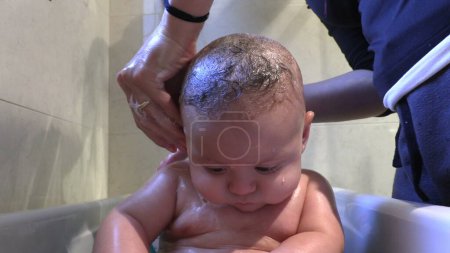 Photo for Bathing baby infant inside bathtub - Royalty Free Image