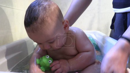 Photo for Bathing toddler baby inside bathtub - Royalty Free Image