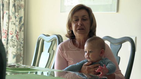 Téléchargez les photos : Grand-mère tenant petit-fils bébé tout-petit dans un moment franc - en image libre de droit