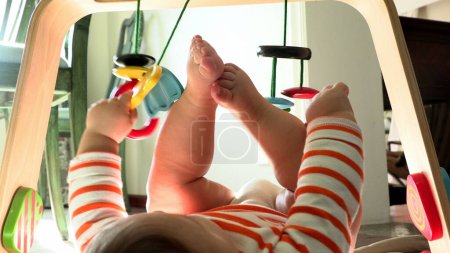 Téléchargez les photos : Curte bébé bébé jouant avec jouet en bois pour enfant - en image libre de droit