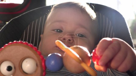 Foto de Adorable juguete mordedor de bebé en silla de niño - Imagen libre de derechos
