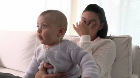Téléchargez les photos : Fatigué mère frotter les yeux tenant bébé assis à la maison canapé se sentir épuisé - en image libre de droit