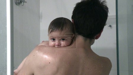 Téléchargez les photos : Parent dans la douche bain douche ensemble père et fils relation - en image libre de droit