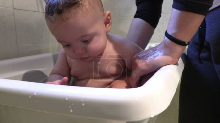 Photo for Bathing cute baby infant inside bathtub - Royalty Free Image