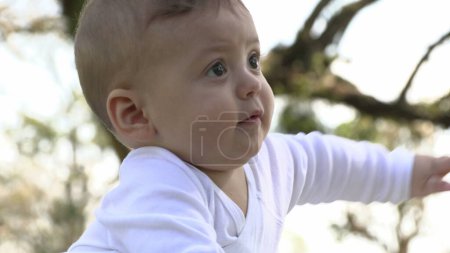 Photo for Curious baby infant boy learning about the world in outside park - Royalty Free Image