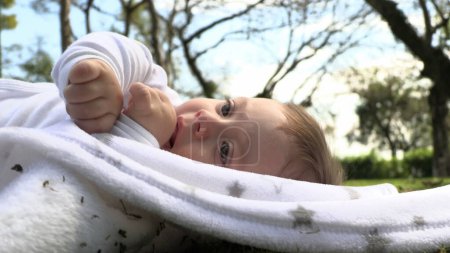 Photo for Beautiful child baby laid on grass in outdoor discovering the world - Royalty Free Image