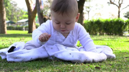 Foto de Lindo bebé niño niño en el parque natural tocando hierba - Imagen libre de derechos
