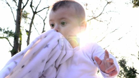 Téléchargez les photos : Joyeux bébé enfant heureux dans la nature en plein air avec un soleil éclat de lentille pendant l'heure dorée coucher de soleil - en image libre de droit