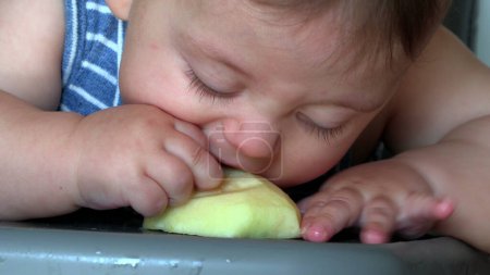 Photo for Baby eating fruit, closeup infant toddler biting apple - Royalty Free Image