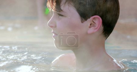 Foto de Niño lanzando algo dentro de la piscina climatizada agua - Imagen libre de derechos